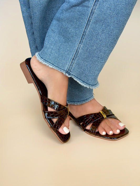 Close up of Kylie Collection ladies coffee brown flat sandals with crocodile texture crisscross straps and a small gold buckle detail in Sri Lanka