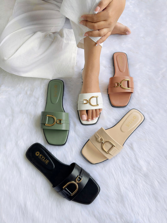 Top down view of Kylie Collection ladies flat sandals featuring wide straps with gold buckle details in black, green, white, salmon pink, and cream, with one pair worn by a model in Sri Lanka